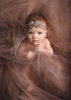 a baby wearing a tiara and posing for the camera