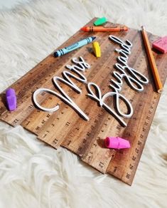 a wooden sign that says happy birthday next to crayons