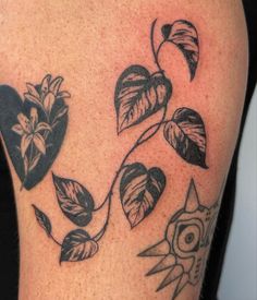 a close up of a tattoo on a person's arm with flowers and leaves