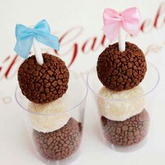 two desserts with chocolate and marshmallow toppings in small cups on a table