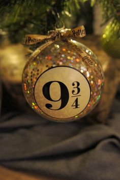 an ornament hanging from a christmas tree with the number nine on it's side