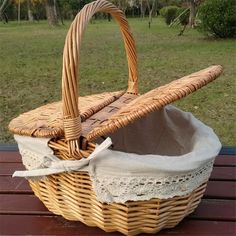 a wicker basket sitting on top of a wooden table next to a grass field