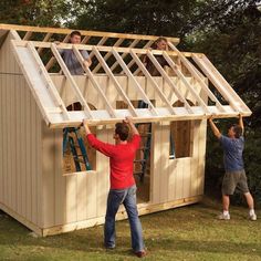 two men are building a small house in the yard while another man is working on it