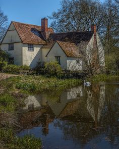 an old house with a pond in front of it