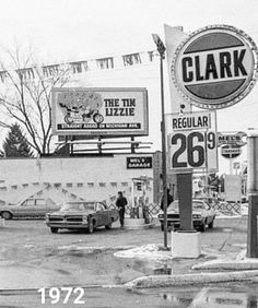 an old black and white photo of cars parked in front of clark's pizza