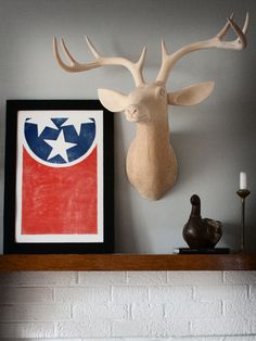 a deer head mounted on the wall above a fireplace