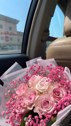 a bouquet of pink roses in the back seat of a car