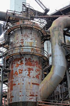 an old rusted metal structure with pipes