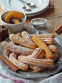 a plate full of churros and cinnamon sticks on a table with other food items