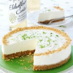 a cheesecake on a green plate with a bottle of wine in the back ground