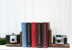 three books are stacked on top of each other with a camera in front of them