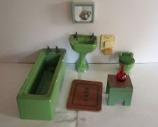 a green toy bathtub sitting on top of a white floor next to a toilet