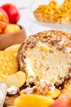 a cheese ball covered in nuts next to apples and crackers