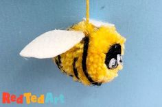 a yellow and black stuffed animal hanging from a string on a blue background with the words red ted art written below it