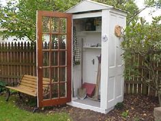a garden shed with its door open and gardening tools in it