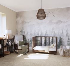 a baby's room with a crib, rocking chair and large wall mural