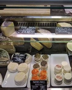 a display case filled with lots of different types of cheeses and other food items