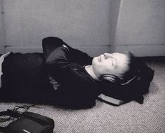 a young man laying on the floor with headphones
