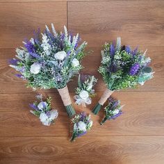 three bouquets of flowers sitting on top of a wooden floor