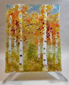 a glass painting with trees and leaves on it
