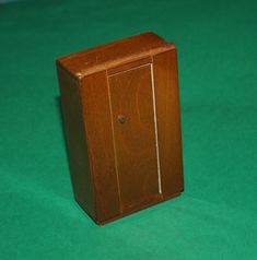 a small wooden cabinet sitting on top of a green surface