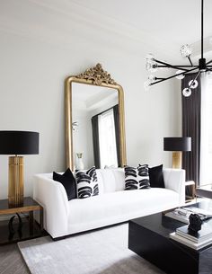 a living room filled with furniture and a large mirror