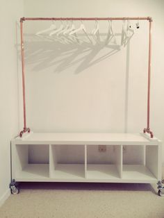 a white shelf with some metal pipes on it