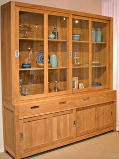 a wooden china cabinet with glass doors and drawers