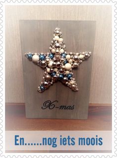 a star shaped brooch sitting on top of a wooden plaque with words written in french