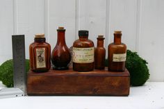 several brown bottles sitting on top of a wooden stand