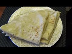 two quesadillas on a white plate sitting on top of a black table