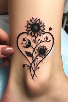 a heart shaped tattoo with sunflowers on the side