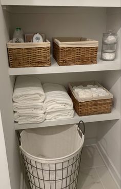the shelves are organized with baskets and towels