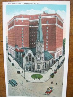 an old postcard with a church and cars on the street