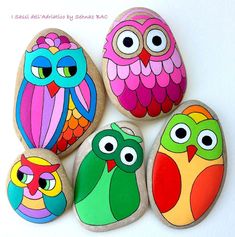 four painted rocks with owls on them sitting next to each other in front of a white background