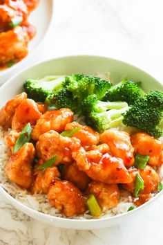 two bowls filled with chicken and broccoli on top of white rice covered in sauce
