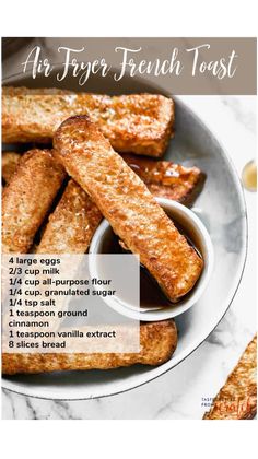 french toast sticks with dipping sauce in a bowl on a marble countertop next to breadsticks