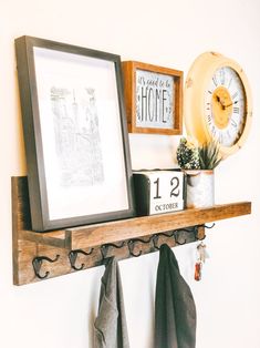 a wooden shelf with two framed pictures on it and other items hanging on the wall