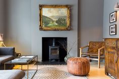 a living room filled with furniture and a painting hanging on the wall over a fire place