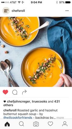 two bowls of carrot soup with nuts and garnishes on the side, one being spooned out