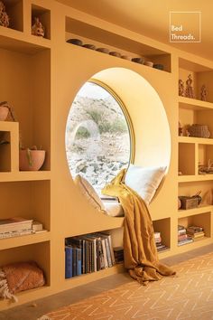 a round window in the side of a wall next to bookshelves filled with books