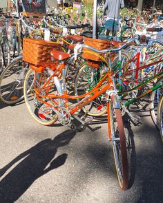 many bicycles are lined up on the street with people looking at them in the background