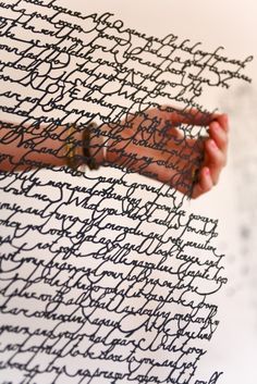 a woman holding onto a piece of paper with writing on it and her hand in the middle