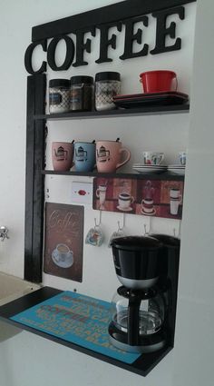 there is a coffee maker and cups on the shelf