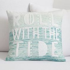 a pillow with the words roll with the tide on it