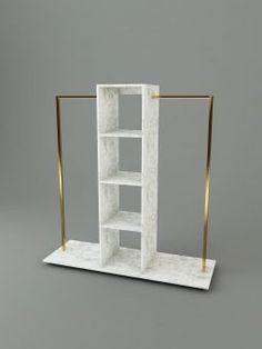 a white marble shelf with gold handles