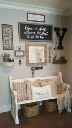 a white bench sitting in the middle of a living room next to a wall with pictures on it