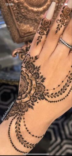 a woman's hand with henna tattoos on it