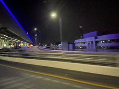 a blurry photo of an overpass at night with buildings and street lights in the background