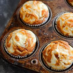 a muffin tin filled with orange cupcakes